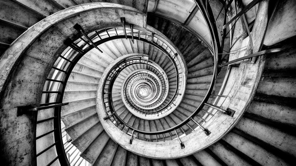 A concrete spiral staircase photographed from below
